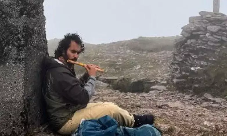 Mrinank Sharma playing flute outdoors, reflecting his shift from AI to poetry and personal expression